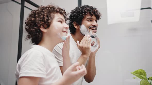 Curlyhaired Brothers Put Shaving Cream on Face in Morning