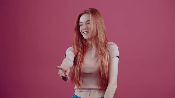 Shocked Young Redhead Cheerful for 20 Years in a Pink Casual Tshirt Isolated on a Pink Background