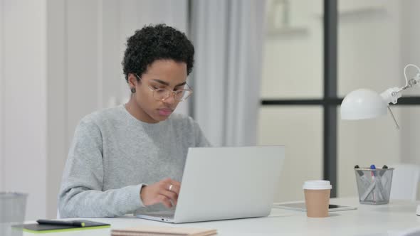 African Woman with Laptop Looking at Camera 