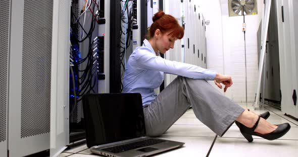 Stressed Technician Sitting on Floor Beside Open Server