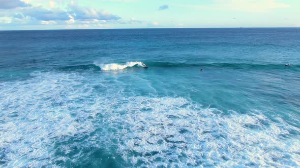 aerial shot of surfer carving waves on a longboard in hawaii