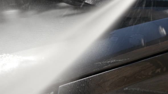 Gray color hood washing with automatic car pressure washer close-up video