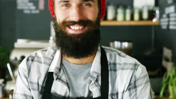 Portrait of waiter standing with arms crossed