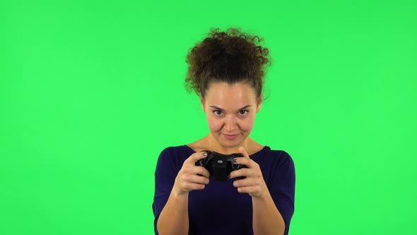 Portrait of Curly Woman Playing a Video Game Using a Wireless Controller with Joy. Green Screen