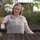 Woman Sprays Pots with Earth in Which Seedlings Grow with Water From a Spray Gun - VideoHive Item for Sale