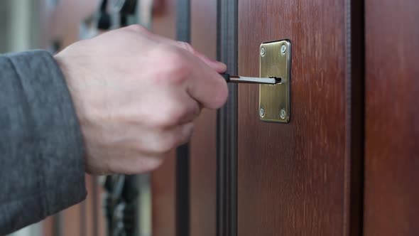 man opens the door with a key, close-up of hands