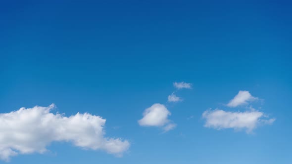 Timelapse of cumulus cloud movement against a clear blue sky