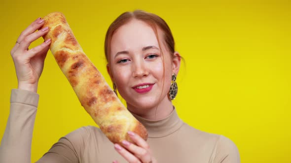 Closeup Portrait of Charming Cheerful Redhead Woman with Green Eyes Posing with Baguette at Yellow