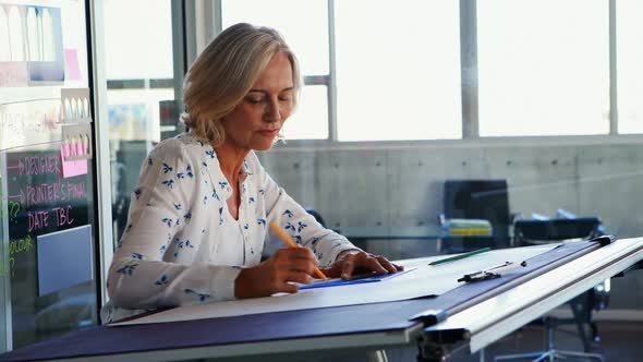 Female architect working on blueprint over drafting table 4k