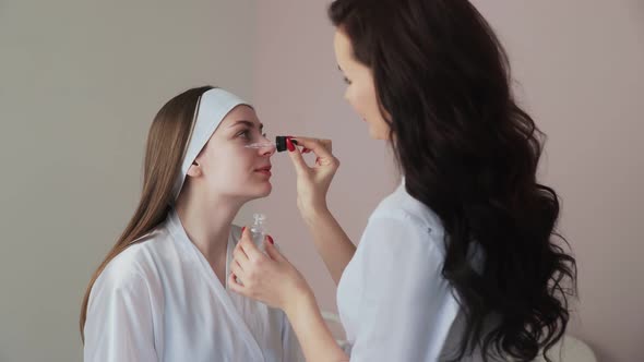 Professional Cosmetologist Applies Peeling Lotion on Woman Client Face in Beauty Clinic Salon