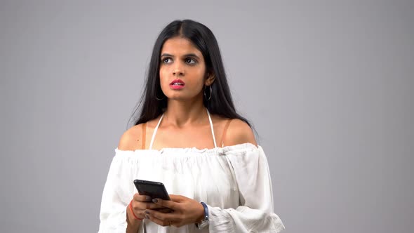 Angry Indian girl using smartphone