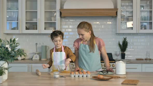 Loving Mother and Daughter Prepare Holiday Cookies in the Kitchen, Knead the Dough. The Daughter