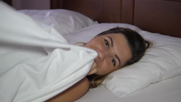 Smiling Woman In Bed To Get Out From Under The Blanket, Lays Down On The Pillow