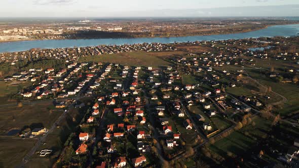 Aerial Overview of Many Small Modern Houses in Village Near River