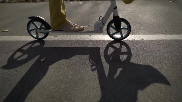 Barefoot man riding scooter in public playground, Zagreb, Croatia.