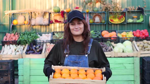 Woman Farmer (Seller) With Oranges at the Farmers Market.