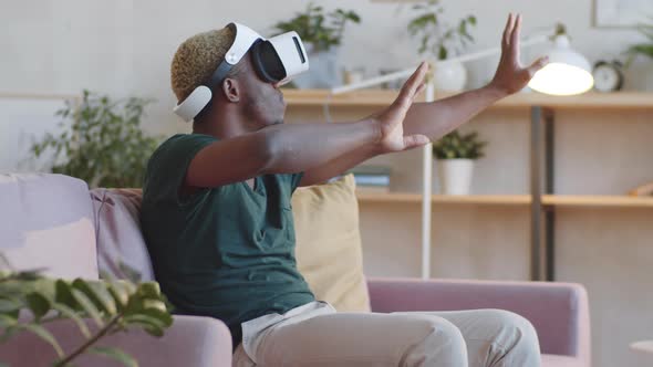 Afro-American Man Using VR Glasses at Home