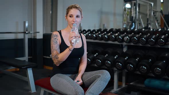 Fitness Center  Young Girl Refreshes From Sports at a Gym