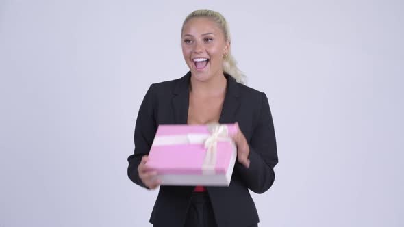 Young Blonde Businesswoman Opening Empty Gift Box As Prank