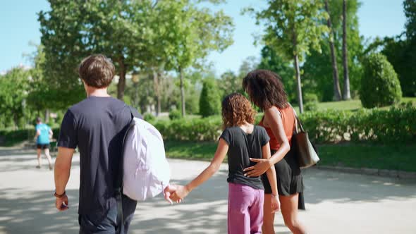 Smiling multiethnic family talking and walking in the park