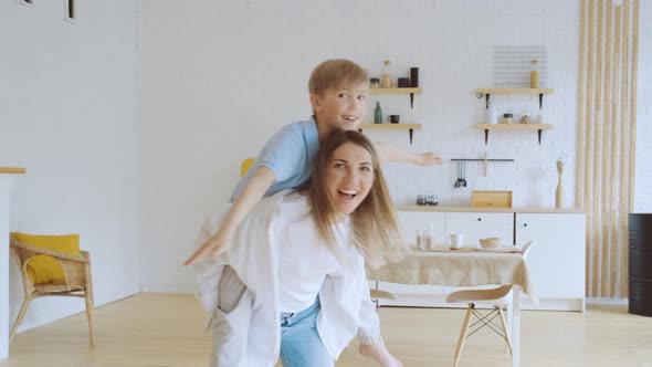Young Mother and Little Son Have Fun at Home in Living Room Mom Carries Her Boy