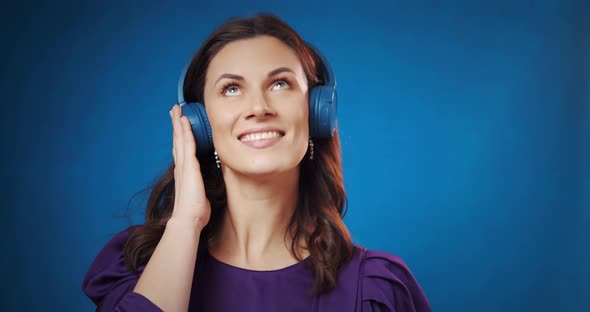 Happy Young Woman Listen Music in Headphones at Studio