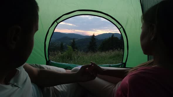 A Loving Couple is Resting in the Mountains They are Sitting in a Tent and Talking