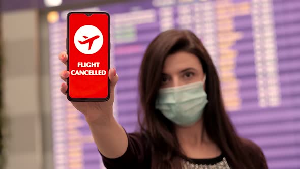 Close Up, Woman, in Protective Mask, Holds Smartphone with Airplane Icon, Flight Cancelled Sign, on