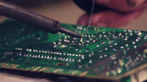 Closeup of a Soldering Iron Repairing an Electronic Circuit Board