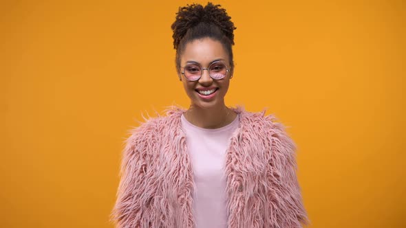 Attractive and Stylish Girl Smiling, Standing on Yellow Background, Good Mood