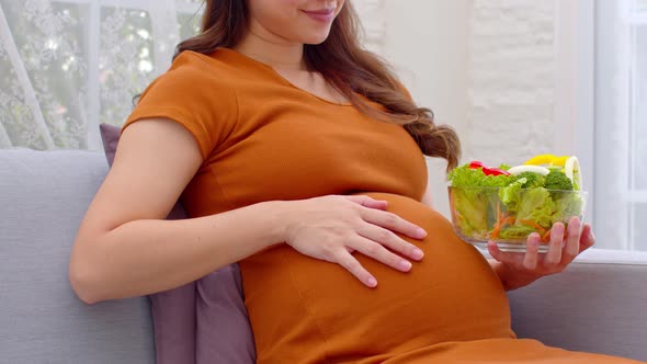 Close up Pregnant Young woman eat mixture of vegetables Fresh Salad at home