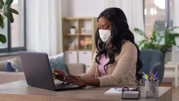 Woman in Mask with Laptop at Home Office