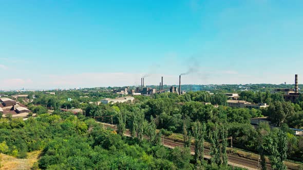 Railway To the Plant in the Industrial Area of the City Near a Residential Area with Green Trees.