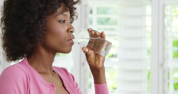 Woman drinking glass of water and smiling