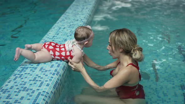 Mother Helps Her Little Daughter to Swim