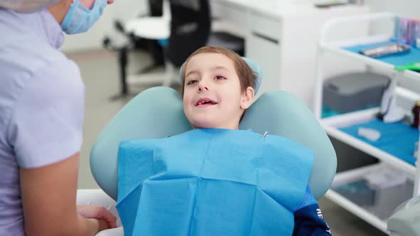 Doctor in Dental Clinic Talking with Funny Little Boy Work Dentist with Children