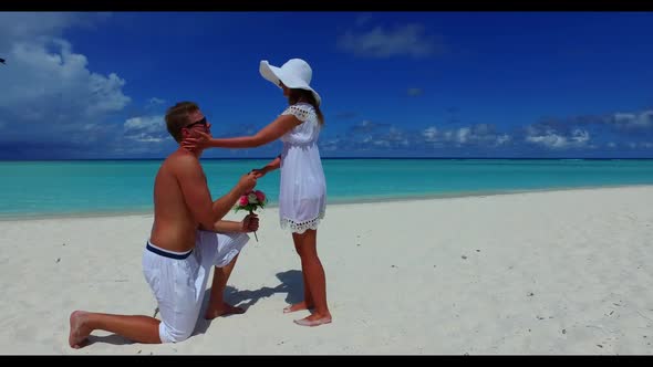 Two people tan on paradise coastline beach lifestyle by blue green sea and bright sand background of