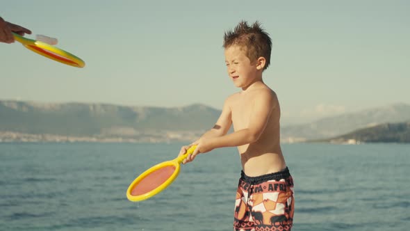 Closeup Slow Motion Video of a Baby Boy with a Racket Playing Tennis