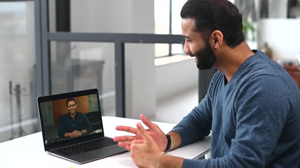Cheerful Indian Male Colleagues Greeting Each Other During Virtual Meeting