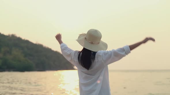 Young Asian woman traveler stretching with arms raised feeling to relax enjoy a holiday.