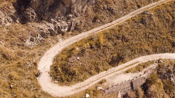 Man Ride Bicycle on the Mountain Road Shot By Drone