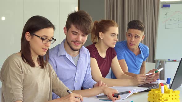 Young People Work in Pairs at the Office