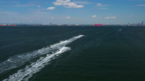 aerial chase of a group of jet ski riders on the waters between Brooklyn & Staten Island, New York,i