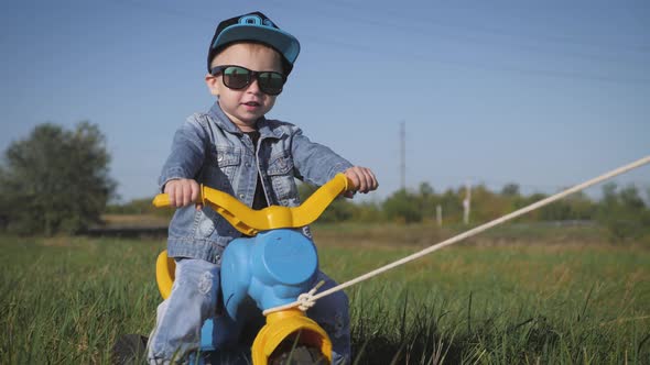 Toddler Kid in Funny Glasses Biking. Helping To Ride a Bike. Learning To Ride a Bike Concept