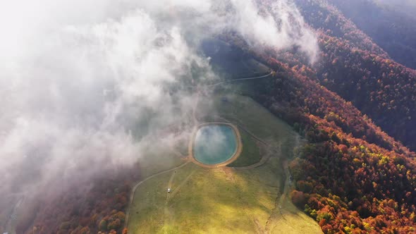 Aerial View of Artificial Lake in Mountain Pine Forest Colored of Autumn Colorsdirty Roadflying