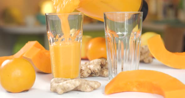 Pumpkin and Ginger Smoothie is Poured Into Glasses Against a Background of Fresh Vegetables and