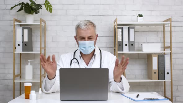 Doctor At Laptop Wearing Face Mask Consulting Patient Online Indoor