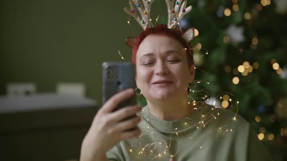 Middleaged Woman Wishes Her Relatives Christmas Via Video Call in Smartphone