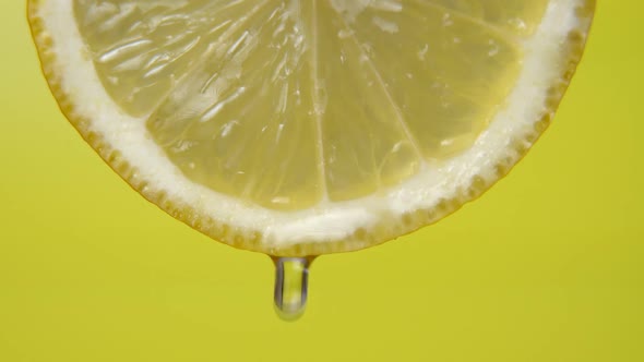 Close Up or Macro of a Slice of Lemon, a Drop of Water Falls in Slow Motion. Concept of Fresh Fruit