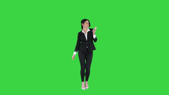 Young Business Woman Listening To Music on the Phone and Dancing To It on a Green Screen, Chroma Key